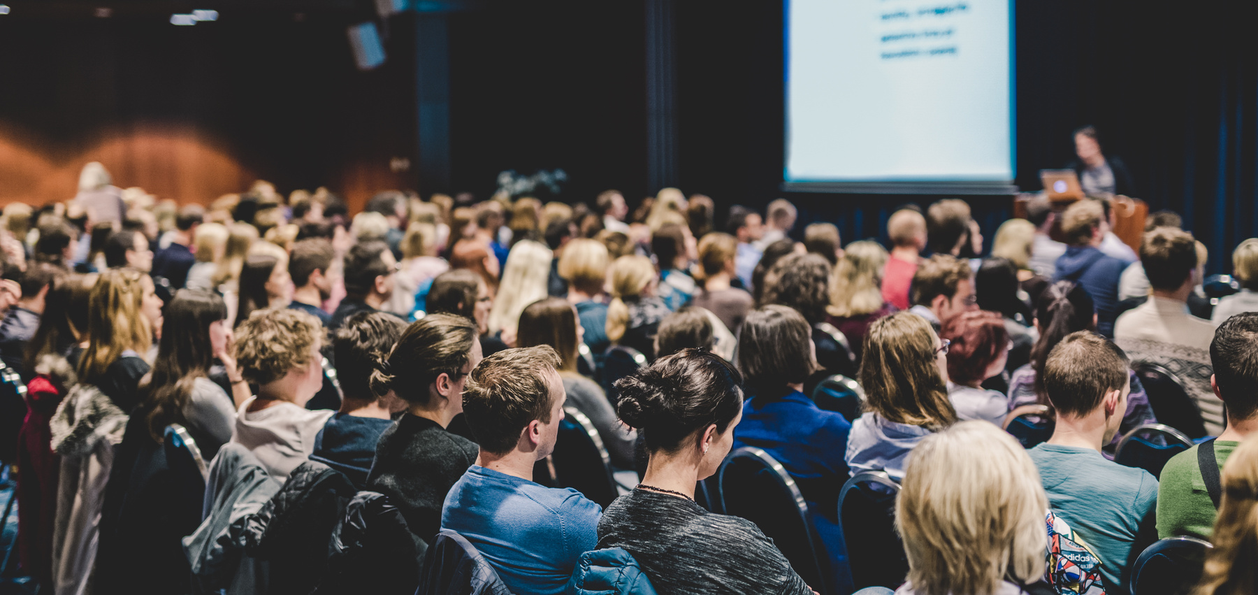 Audience in Lecture Hall Participating at Business Event.