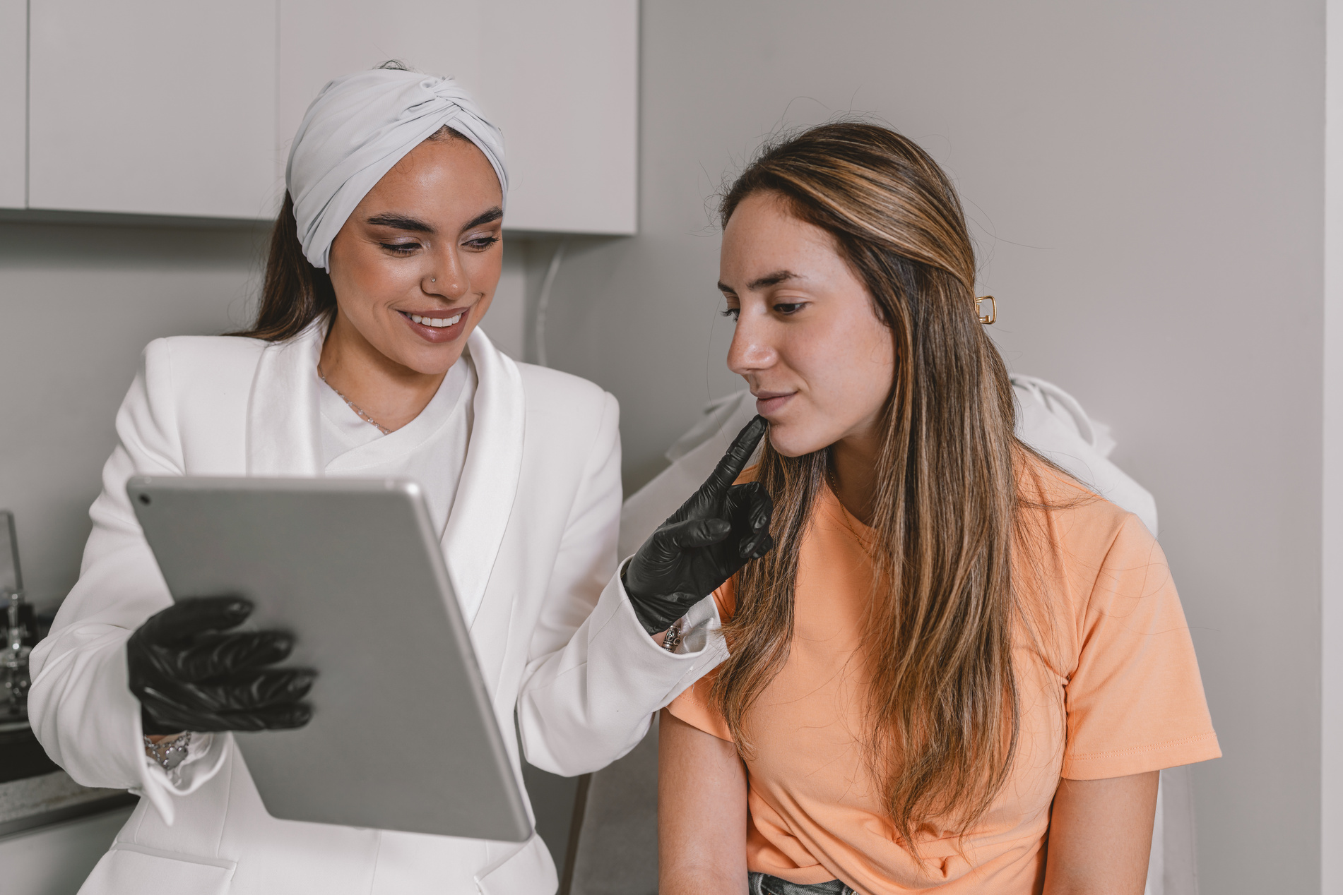 Esthetician explaining a Botox intervention using a digital tabl